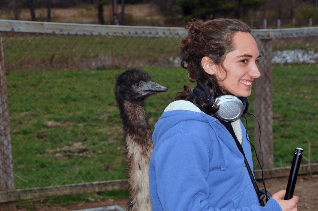 scientist holding sound recorder next to large bird